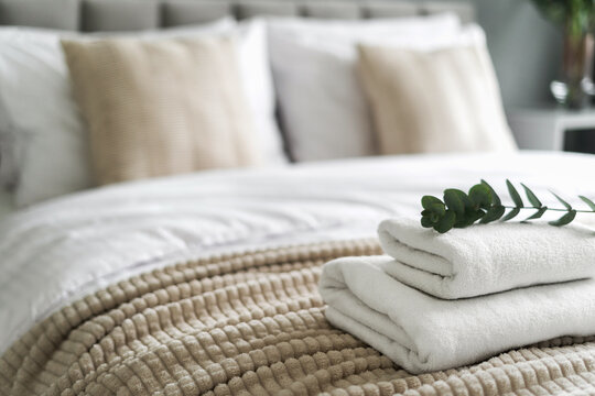 White and fresh neatly folded towels on hotel bed