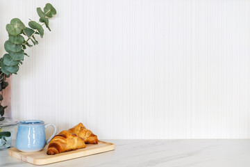 Croissants and cup of coffee on a white countertop