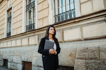 Young businesswoman going to work with laptop in the morning