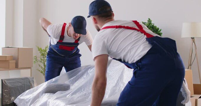 Trauma at work, heavy lifting causing bad back muscle strain, mover getting physical injury carrying armchair for moving, worker feeling back pain, backache problem, health damage, traumatic incident