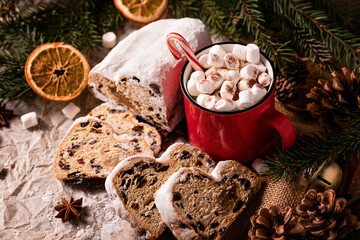 Christmas stollen on wooden background. Traditional christmas german dessert cut into pieces. Cake with nuts, raisins with marzipan and dried fruit on cutting board. baking for xmas