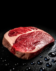 japanese wagyu sirloin with water drops on a pitch solid black background