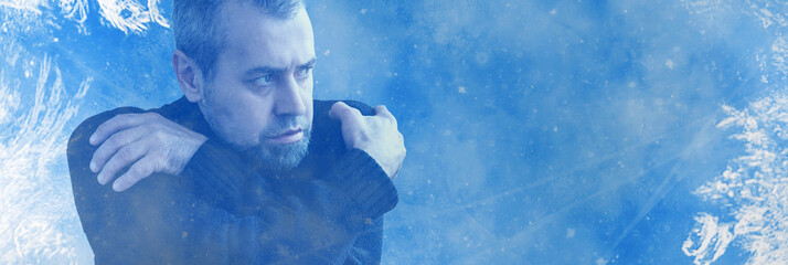 Frozen man shivering from cold weather on a blue snowy background. Winter cold concept
