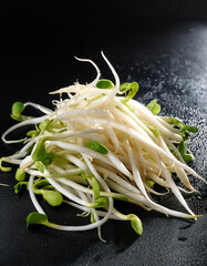 fresh&nbsp;bean sprouts vegetable pile with water drops on a pitch solid black background