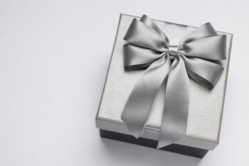 Gift box with bow on light grey background, above view. Space for text