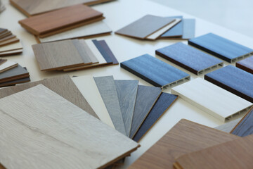 Different samples of wooden flooring on white table