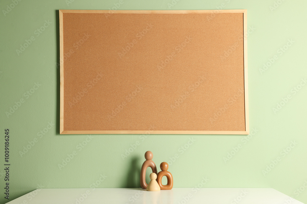 Sticker Cork board and decorative figures on light table near green wall indoors