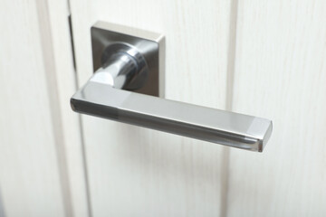 View of door with modern metal handle, closeup