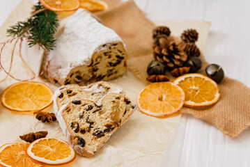Christmas stollen on wooden background. Traditional christmas german dessert cut into pieces. Cake with nuts, raisins with marzipan and dried fruit on cutting board. baking for xmas