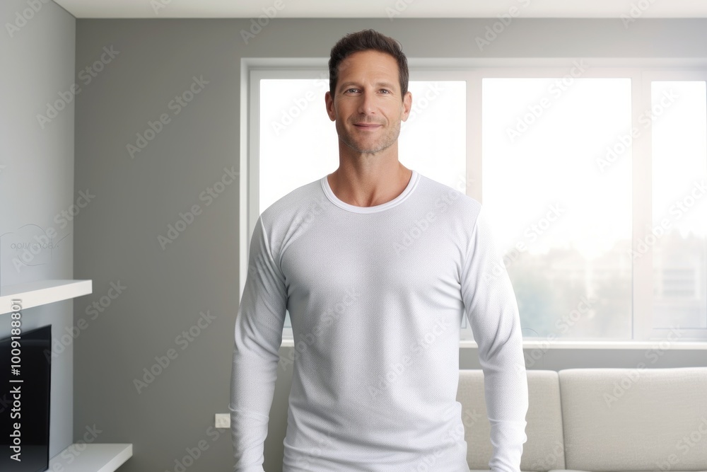 Wall mural Portrait of a content man in his 40s sporting a long-sleeved thermal undershirt over modern minimalist interior