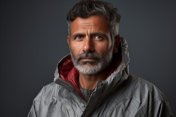 Fototapeta premium Portrait of a tender indian man in his 50s wearing a windproof softshell over modern minimalist interior