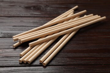 Bamboo drinking straws on wooden table, closeup