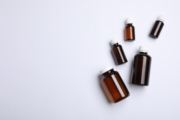 Medical bottles with medicine on white background, top view. Space for text