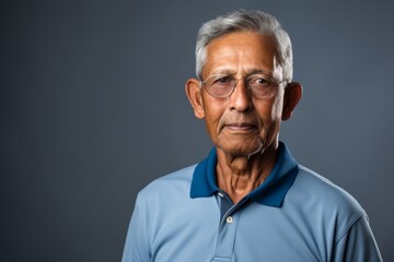 Obraz premium Portrait of a merry indian man in his 70s wearing a breathable golf polo in front of modern minimalist interior