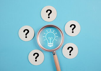 Glowing light bulb inside magnifier glass among question mark for focus and concentrate of creative thinking idea and problem solving concept..