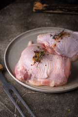 Raw chicken thighs on dark kitchen table