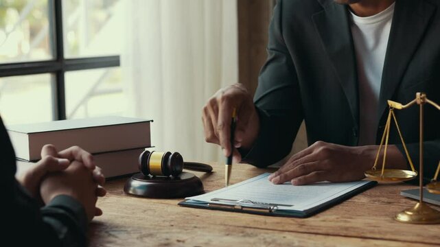 Lawyer sitting at a desk, explaining a contract to a client during a professional consultation in an office setting