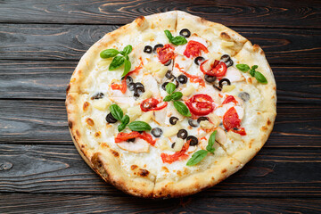 Pizza with mozzarella cheese , olives , chicken , pineapple , basil and tomatoes