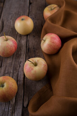 Fresh small apples and towel on wooden table