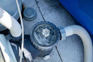 Close-up of a pool filtration system in a backyard garden.