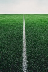 Obraz premium Green soccer field with a white line, minimalistic view
