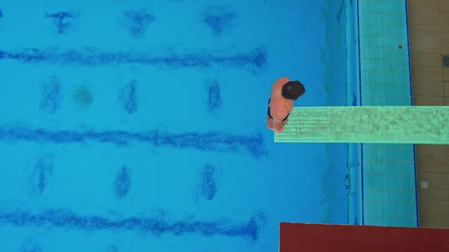 A professional athlete executes a flawless spring dive during a competition. The athlete's precision, strength, and grace are on full display, capturing the intensity and beauty of competitive diving