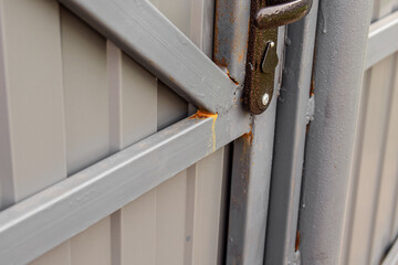 Rust on the corrugated board fence. Corrosion on grey metal gate. Natural