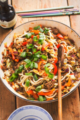 Asian stir fry with spicy beef, noodles, red pepper, cabbage, red onion 