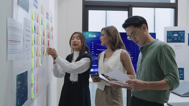 brainstorming session, using sticky notes on a task board (kanban) to organize ideas and workflow in a modern office