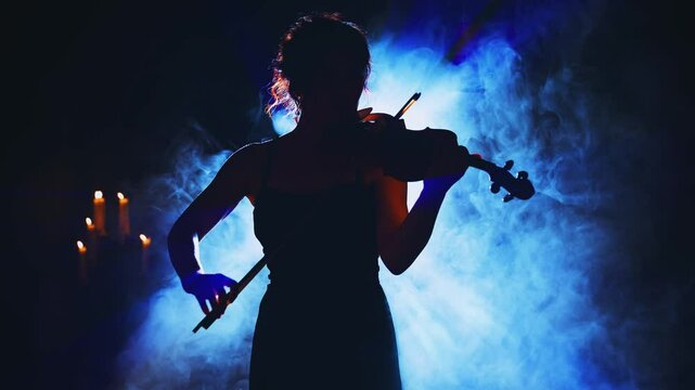 woman violinist playing the violin classic style back rear view. sexy lady Girl musician hands in motion art music artist on stage. Black silhouette vampire in dark room full smoke light blue flare 