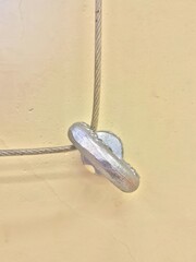 This is a close up view of a metal object that is hanging from a wire