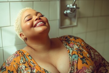 A woman smiling in a bathroom, wearing a floral dress