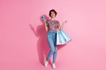 Photo of lovely charming girl wear stylish print clothes make order hold bags space isolated on pink color background