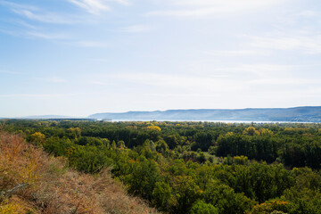 autumn landscape in the mountains. Autumn landscape with dense trees and vibrant foliage under a clear blue sky. from a bird's eye view. Scene of unspoiled nature.