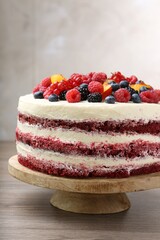 Tasty sponge cake with different fruits on wooden table, closeup