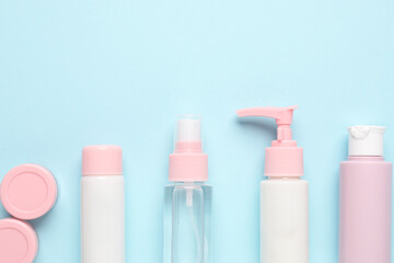 Different cosmetic products on light blue background, flat lay