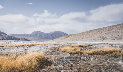 Panoramic landscape of textured Tien Shan mountains in Pamir in Tajikistan, panoramic landscape of a mountain range with snow and glaciers in summer