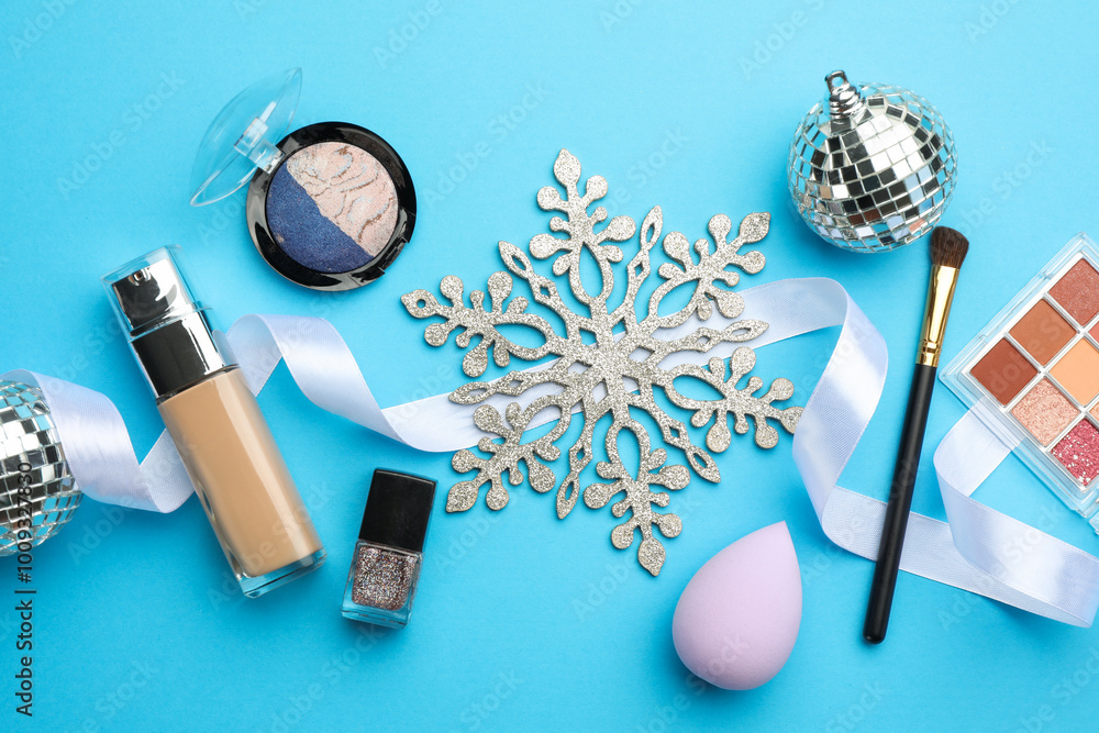 Poster Flat lay composition with makeup products and Christmas decor on light blue background