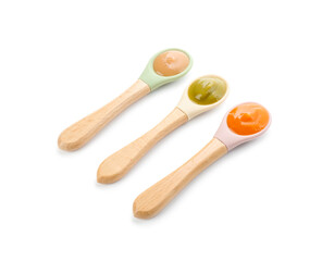 Spoons with different baby food isolated on white