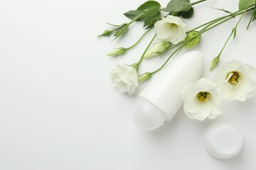 Roll-on deodorant and beautiful eustoma flowers on white background, flat lay. Space for text