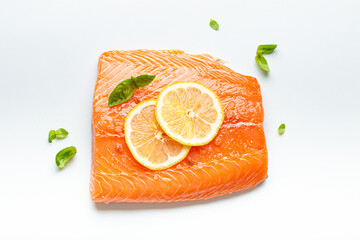 Fresh raw salmon marbled fillet isolated on white background with lemon, coarse salt, green herbs top view. Healthy nutrition and balanced diet.