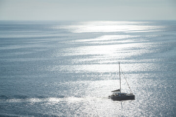 Silhouette of cruising catamaran by a sunny day at the sea