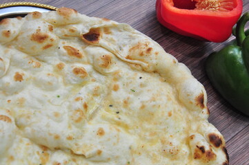 Baked chess naan roti with red green bell pepper background