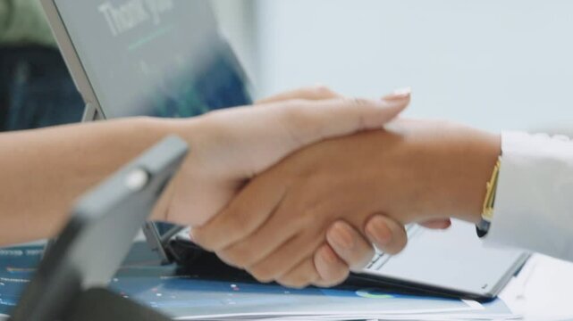 Close up financial officer hand shake deal with business in a meeting room in office