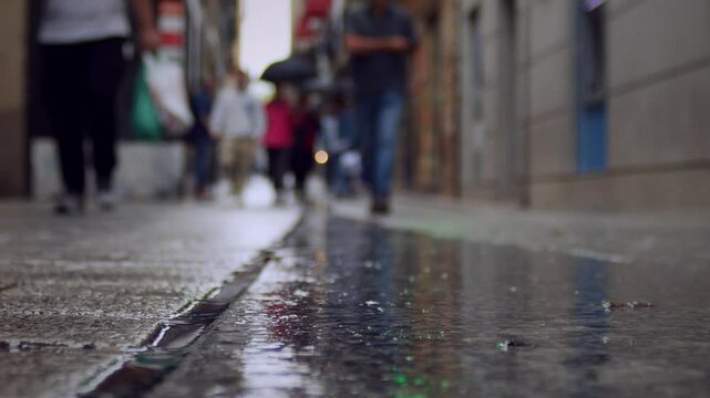 Pedestrians walking on street under light rain