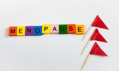 Obraz premium Menopause text in letter blocks with flags