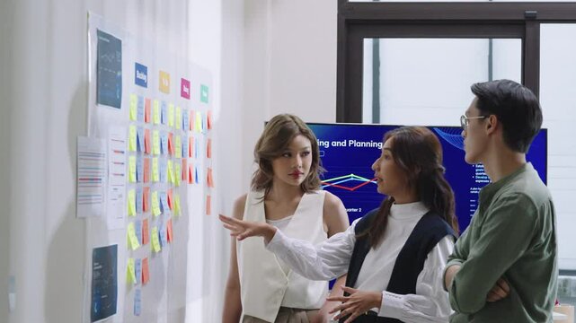 brainstorming session, using sticky notes on a task board (kanban) to organize ideas and workflow in a modern office