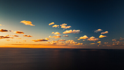  A large body of water beneath a blue sky with scattered clouds