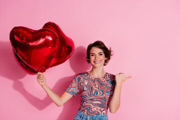 Photo of adorable charming lovely girl wear stylish clothes recommend empty space isolated on pink color background