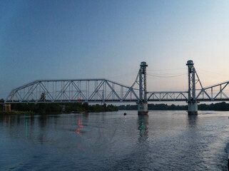 The bridge rises above tranquil waters as day turns to night